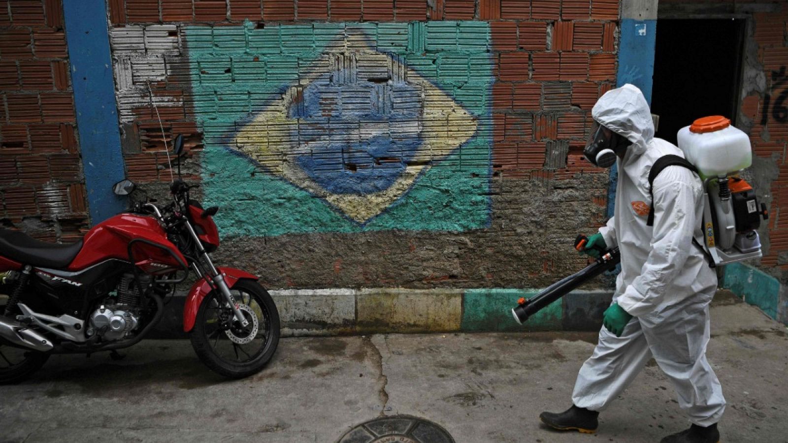 Imagen de un voluntario realizando tareas de desinfección en una favela de Río de Janeiro.
