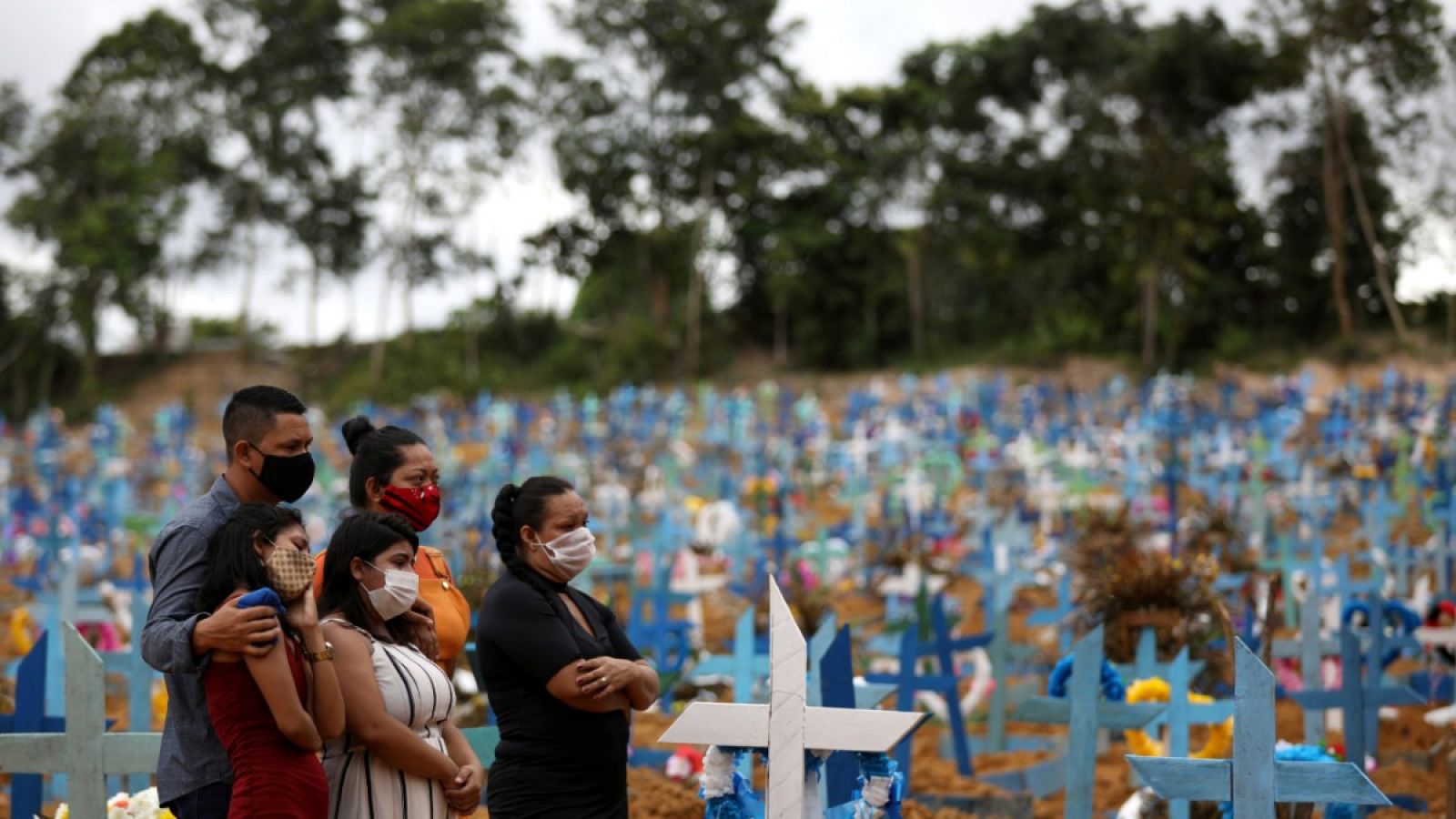 Varias personas con mascarilla asistiendo al entierro de un familiar fallecido con coronavirus en el cementerio Parque Taruma
en Manaos, Brasil.