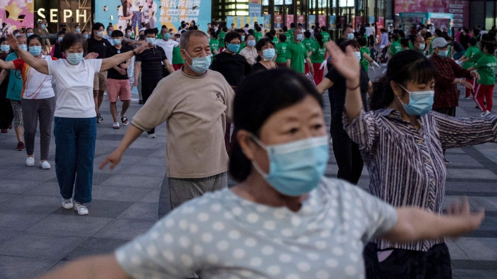 Un grupo practica deporte en un centro comercial de Pekín, con mascarillas y guardando cierta distancia