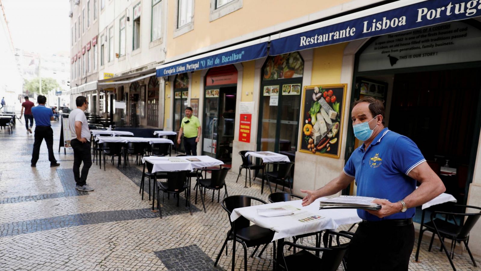 Un camarero invita a los transeúntes a sentarse en un restaurante del centro de Lisboa