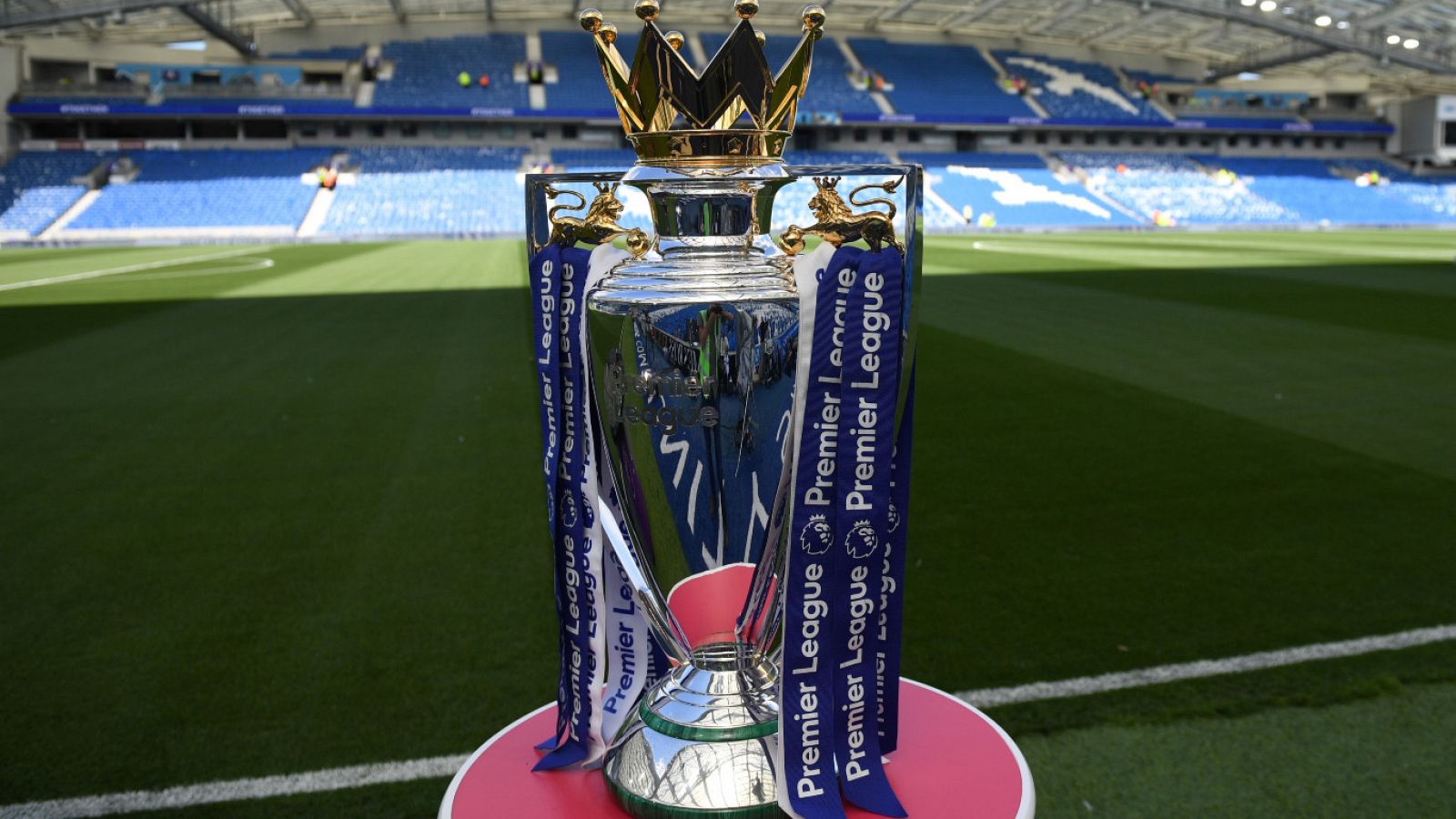 El trofeo de la Premier League sobre una peana en un campo