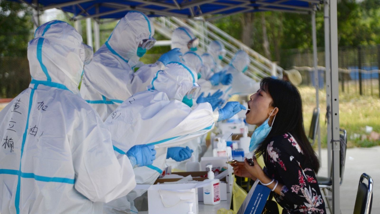 Trabajadores sanitarios chinos realizan pruebas de coranavirus a una residente, después de un brote en Pekín