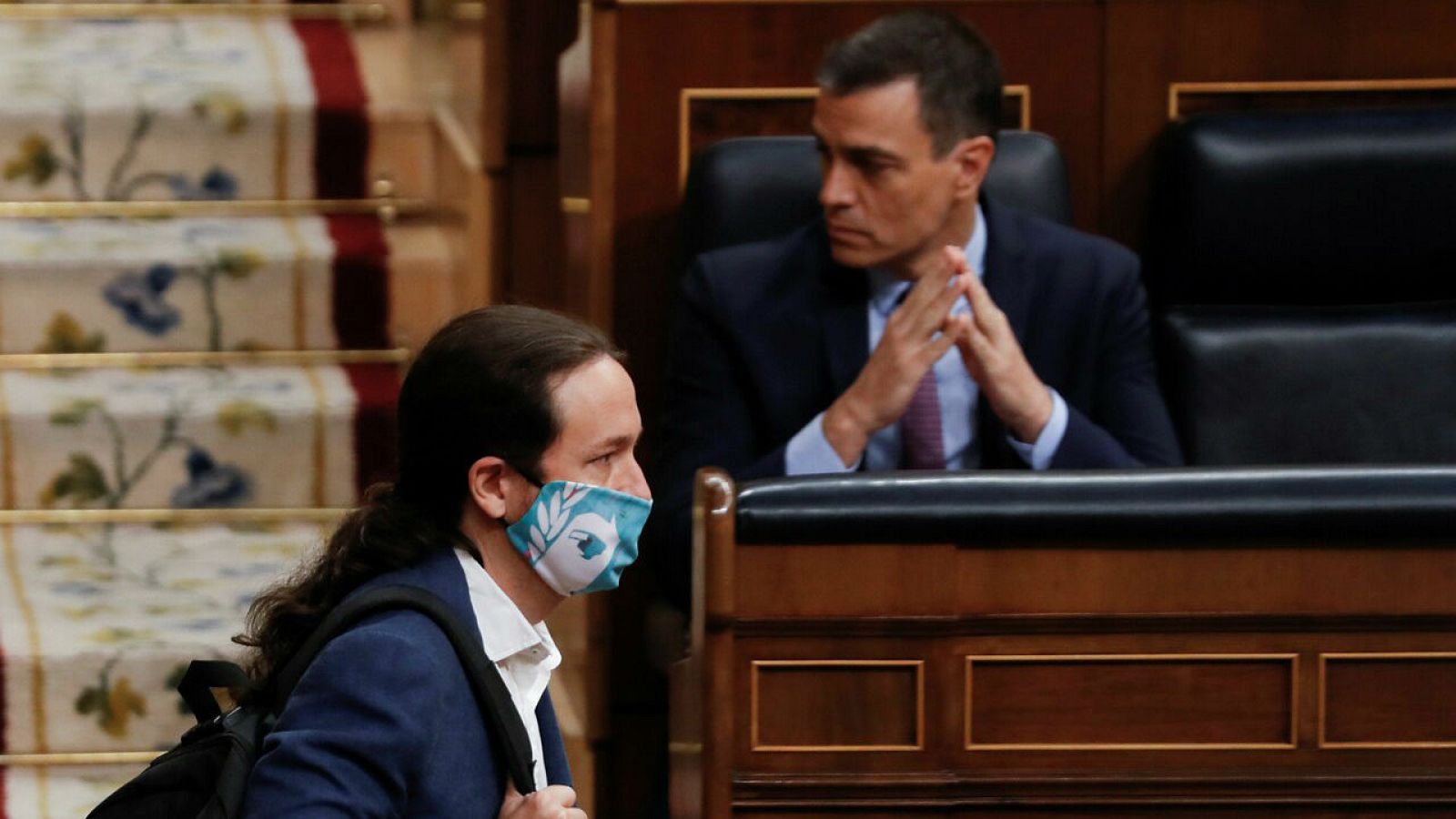 El vicepresidente segundo del Gobierno, Pablo Iglesias, pasa ante el presidente del mismo, Pedro Sánchez, durante su intervención en la primera sesión de control al Ejecutivo en el Congreso.