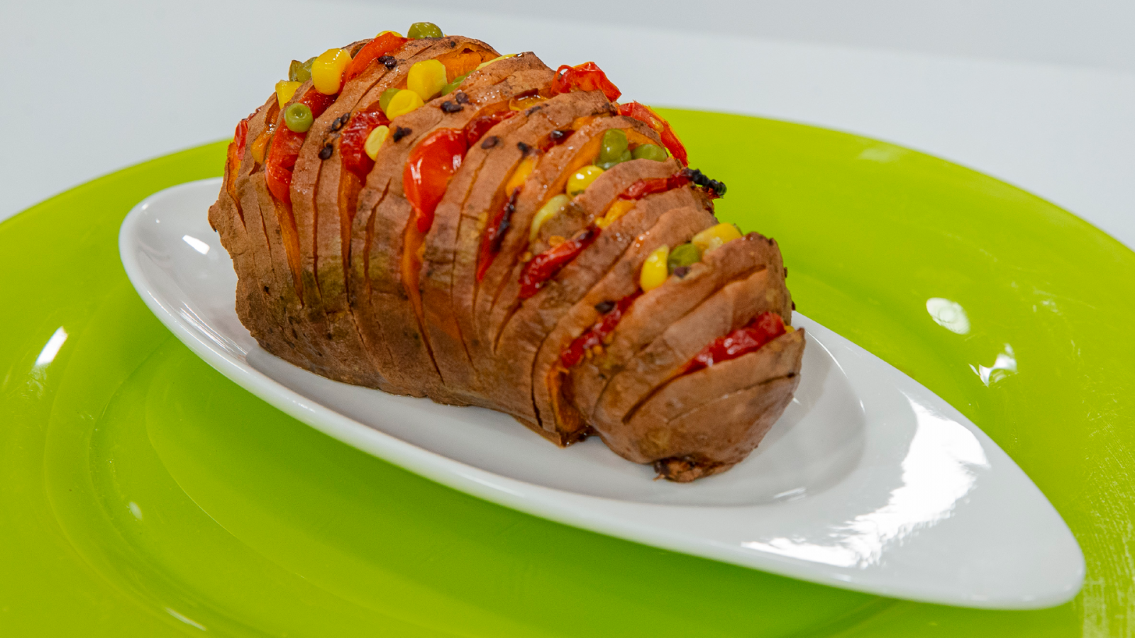 Boniato Hasselback relleno de tomate, cebolla morada, guisantes y maíz