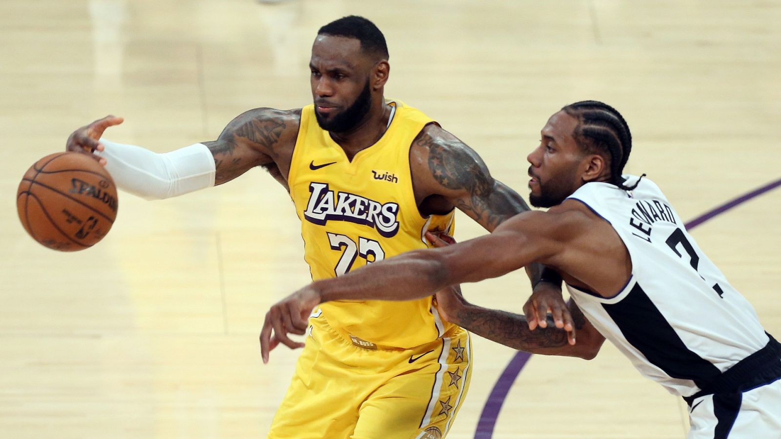 El alero de los Lakers, LeBron James le roba la pelota a Kawhi Leonard