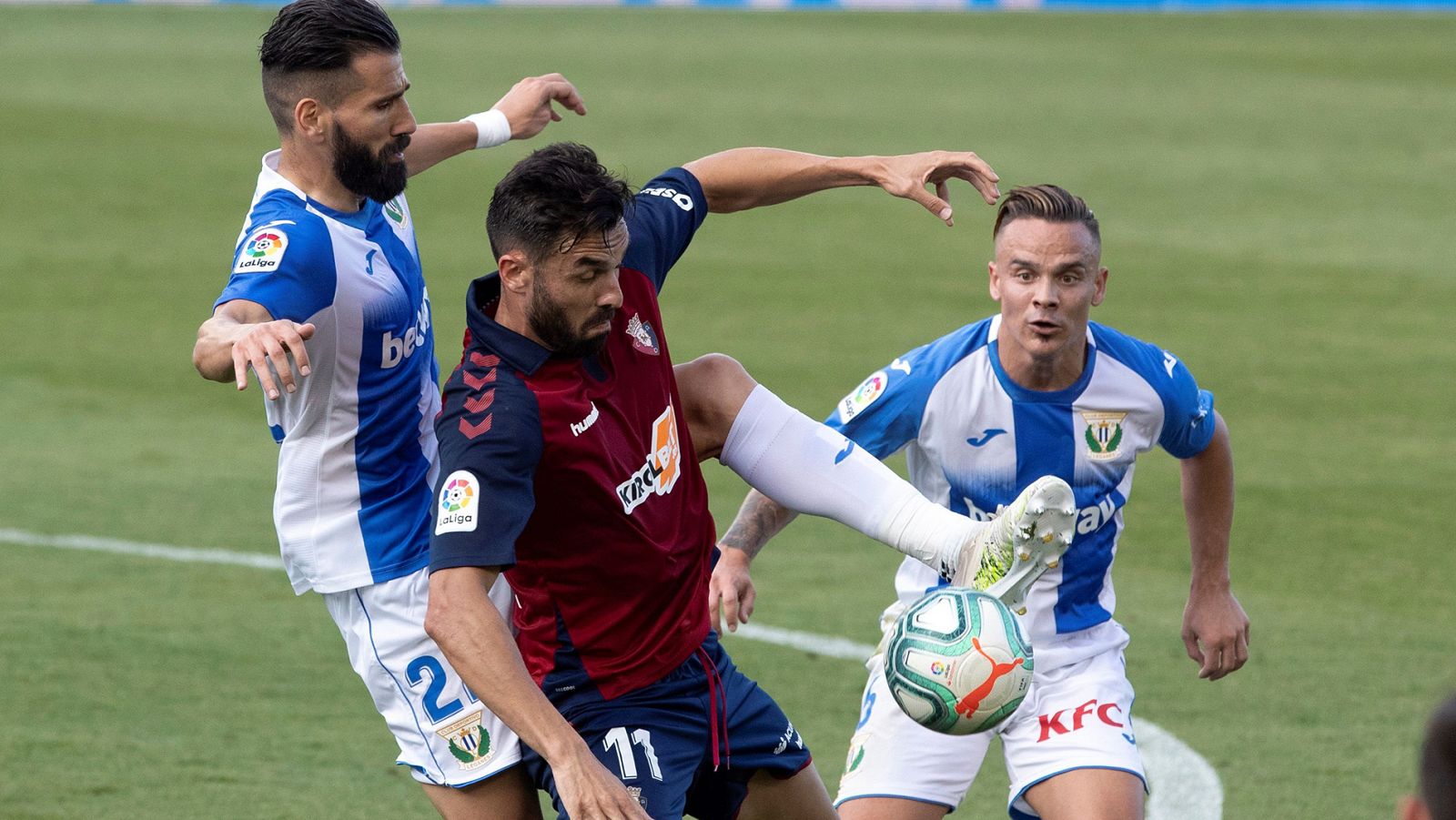 El jugador del Osasuna Enric Gallego (c) disputa un balón con el defensa griego del Leganés, Siovas, y con Roque Mesa (dcha).