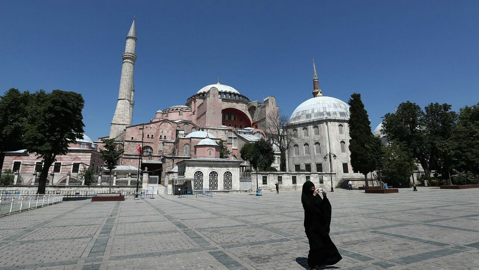 Una mujer vestida con un hiyab toma fotografías frente el Museo de Santa Sofía en Estambul.