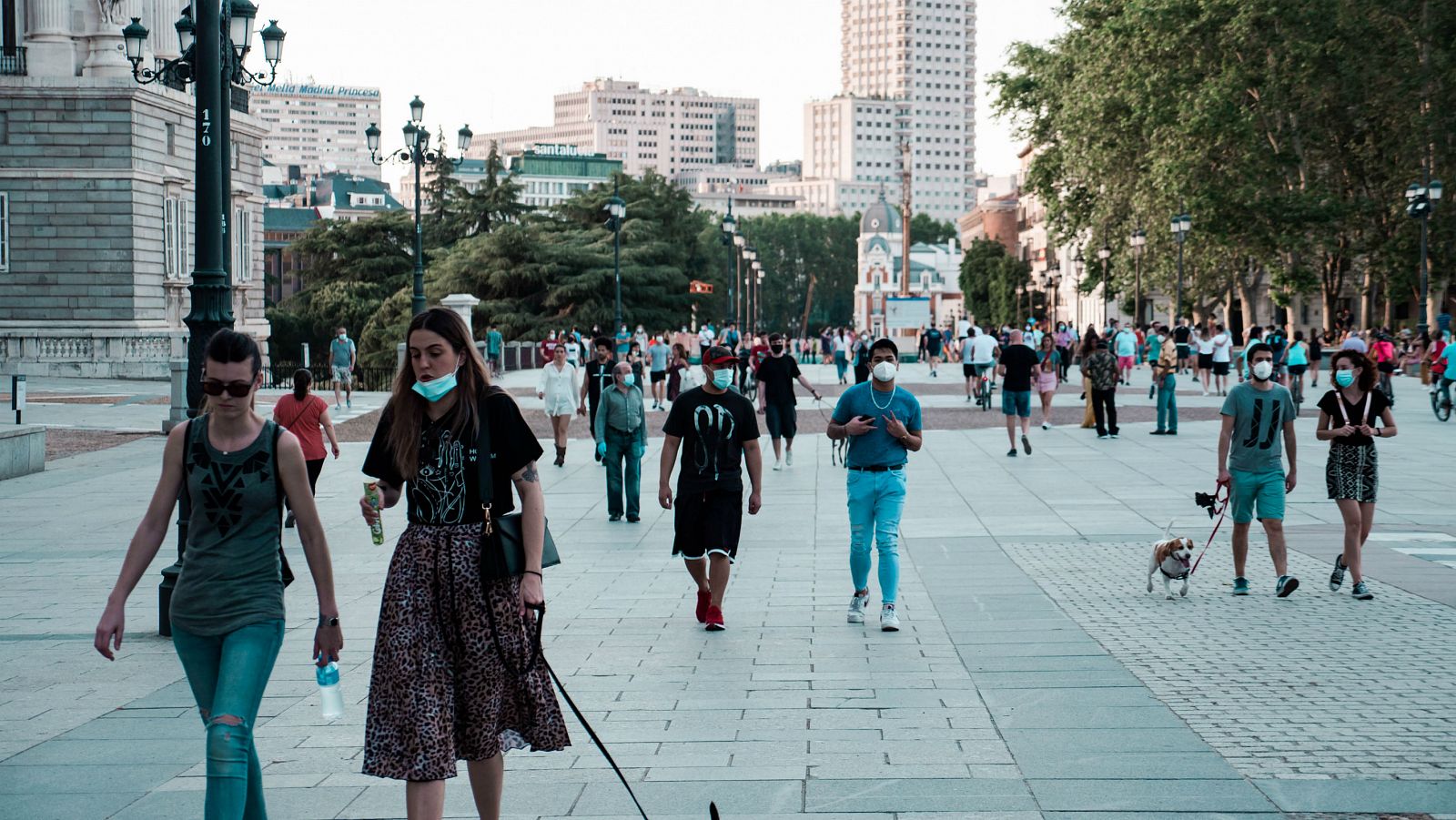 Gente paseando con mascarillas en la Plaza de Oriente de Madrid.