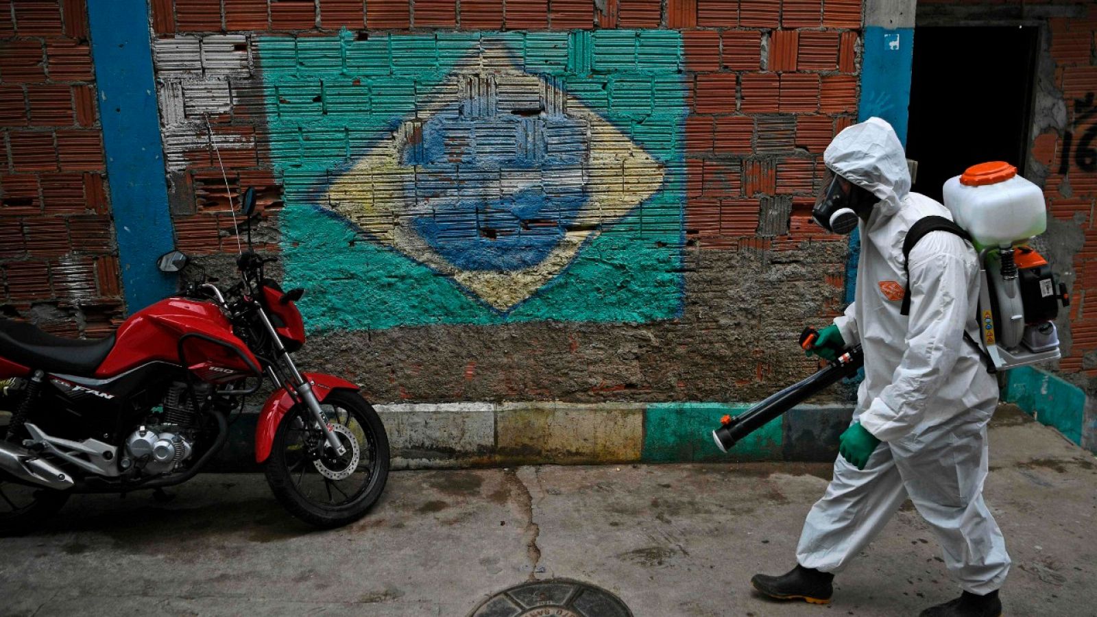Un hombre desinfectando una calle de una favela de Rio de Janeiro, Brasil.