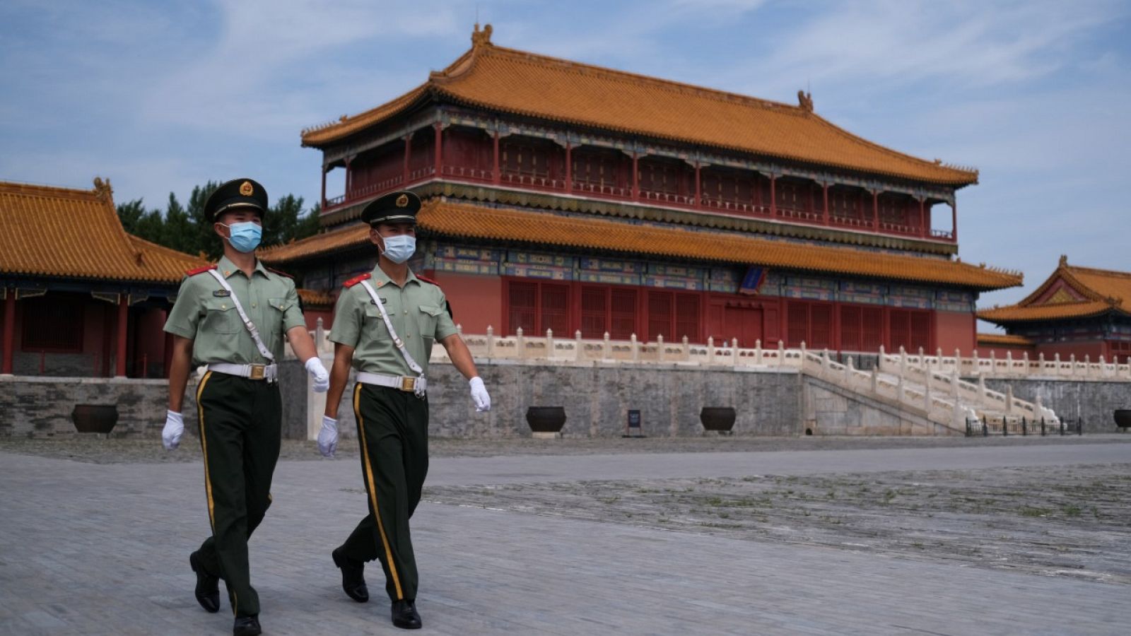 Dos policías con mascarillas caminando por la Ciudad Prohibida, Pekín.