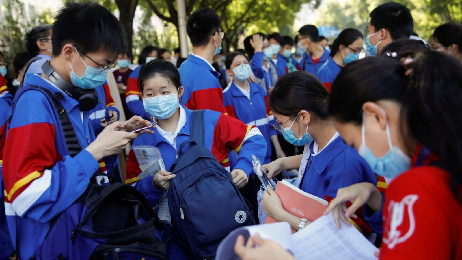 Un grupo de estudiantes con mascarillas se preparan antes de entrar al examen anual nacional de ingreso a la universidad, o "gaokao", que ha sido pospuesto un mes debido al brote de coronavirus, en Pekín, China.