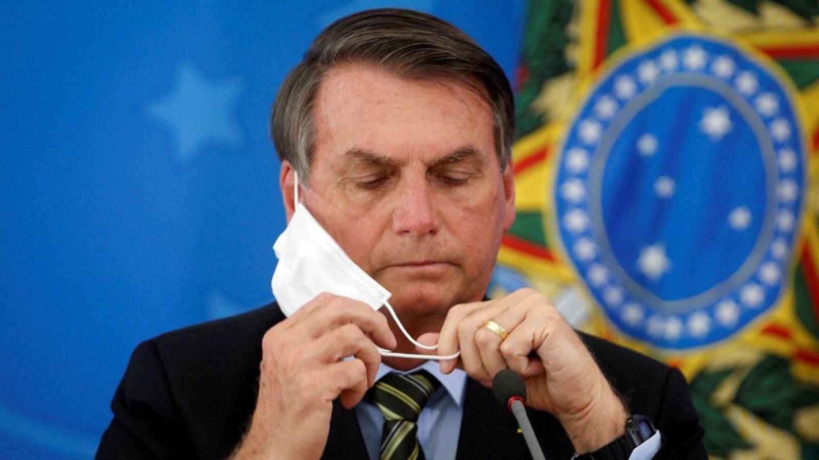 El presidente de Brasil, Jair Bolsonaro, se coloca la mascarilla en una rueda de prensa en una foto de archivo