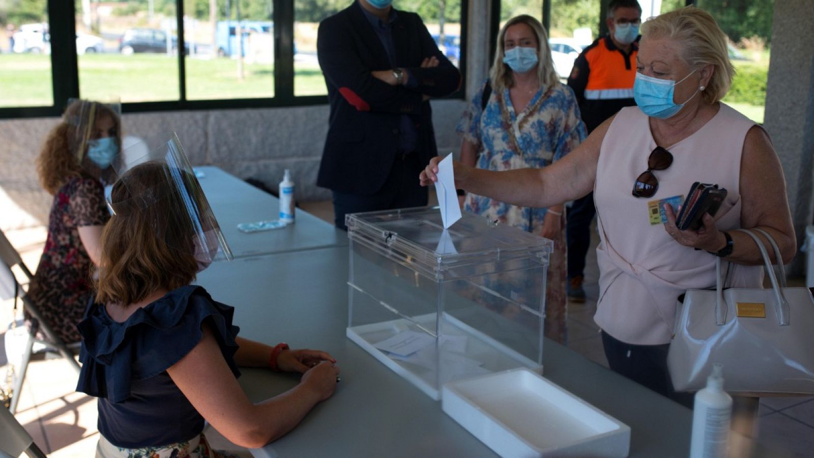 Una mujer introduce una papeleta en una urna durante la simulación de una votación en Galicia