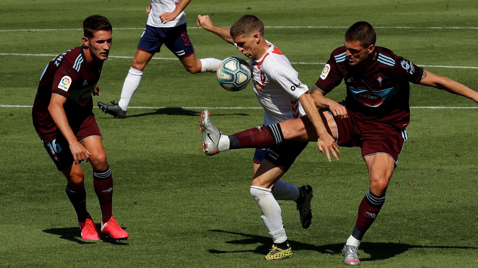 El centrocampista serbio de Osasuna Darko Brasanac (c) disputa un balón ante el centrocampista turco del Celta Okay