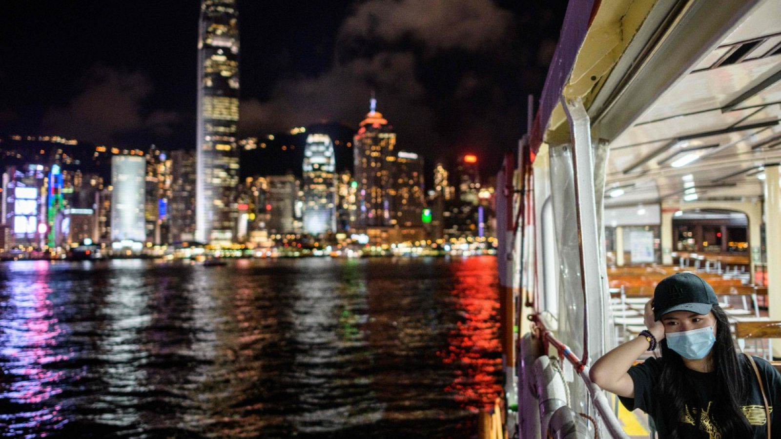 Una mujer con mascarilla cruza el puerto en el ferry de Hong Kong
