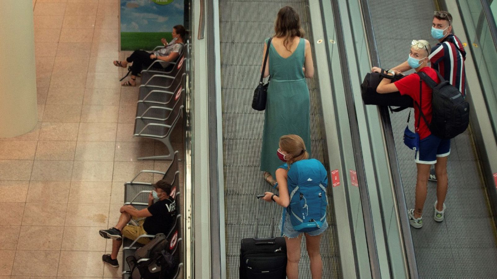 Viajeros con máscaras sanitarias caminan este miércoles por la Terminal 1 del aeropuerto Josep Tarradelles - El Prat, en Barcelona.