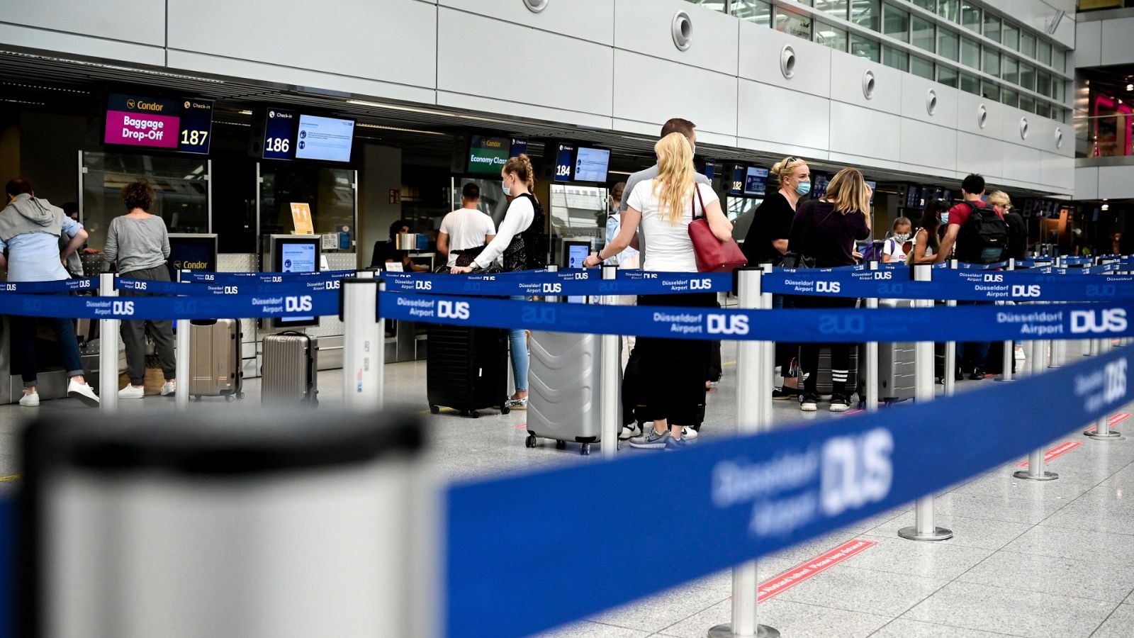 Viajeros esperan en la zona de facturación del aeropuerto de Dusseldorf, Alemania.