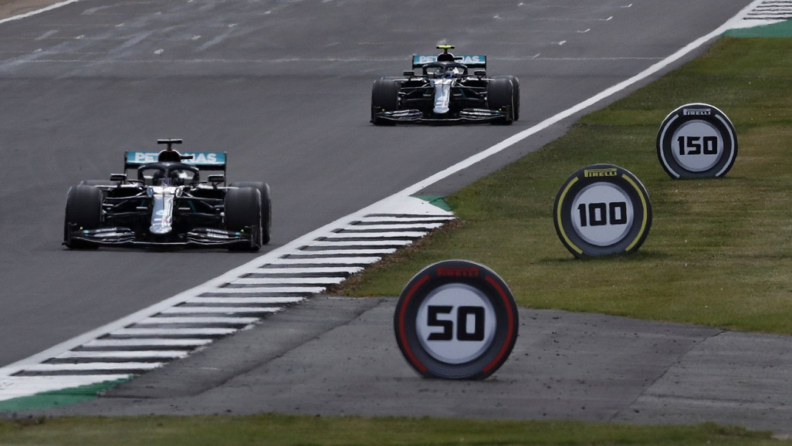 Hamilton y  Bottas durante la carrera disputada el pasado fin de semana en Silverstone, con neumáticos decorativos a un lado del circuito