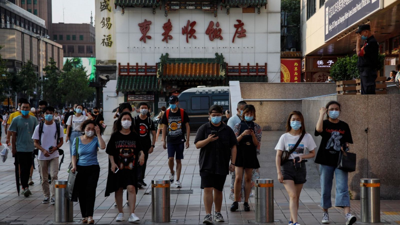 Gente con mascarilla caminando por una calle de Pekín, China.