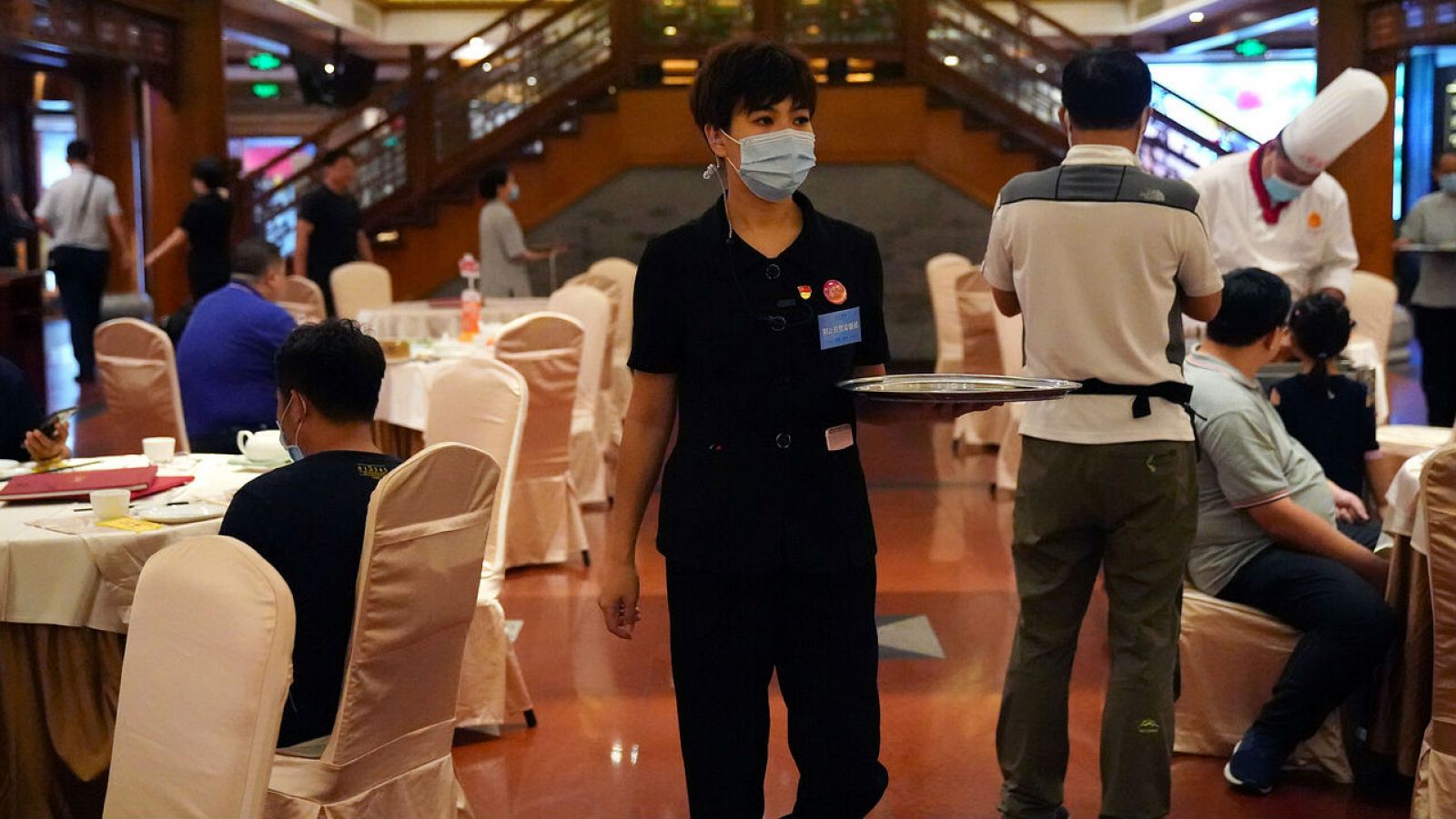 Un miembro del personal que también es supervisor contra el desperdicio de alimentos, sostiene una bandeja en un restaurante en Beijing, China.