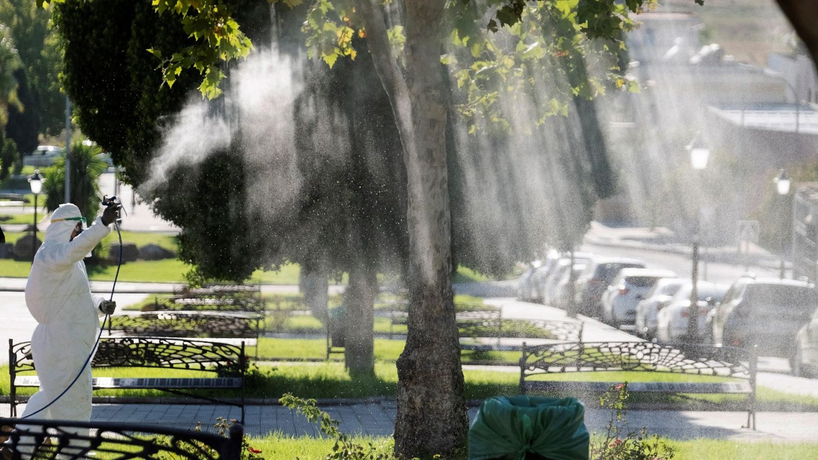 Un operario fumiga unos jardines en la Puebla del Río