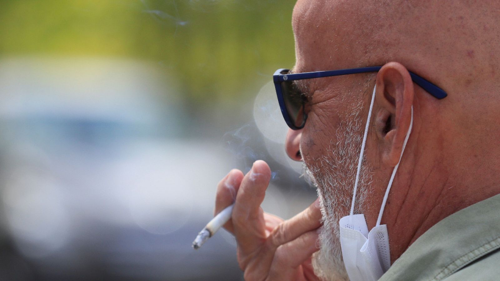 Un hombre se fuma un cigarrillo