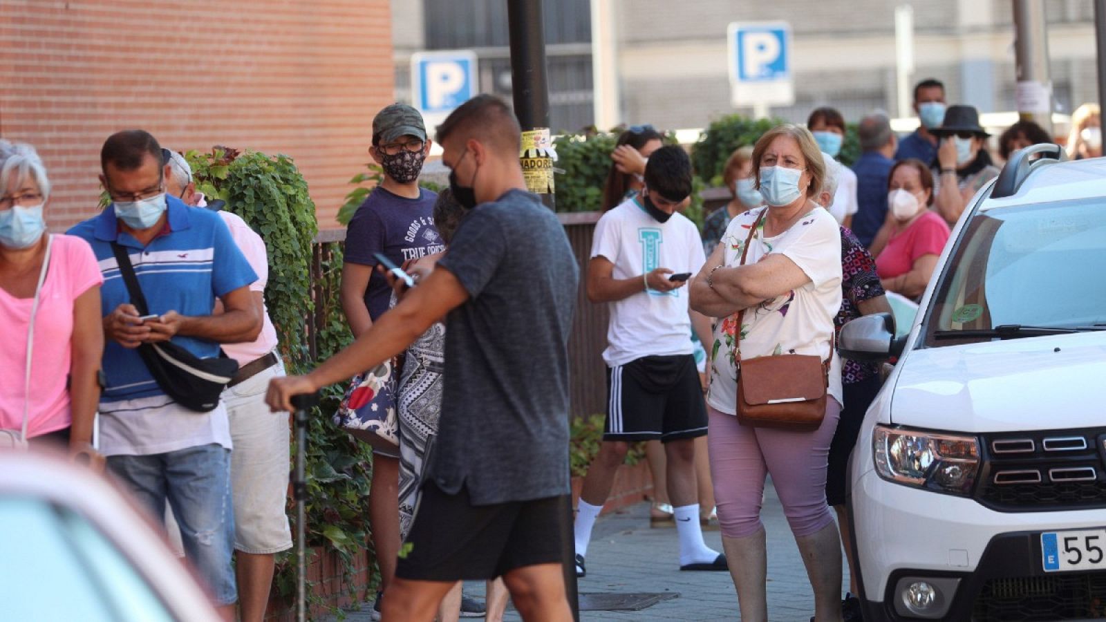 Varios vecinos hacen cola ante un centro sanitario para realizarse una prueba PCR en el distrito madrileño de Villaverde, este miércoles.