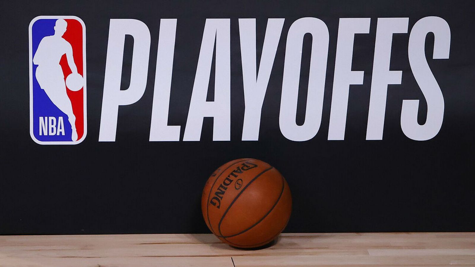 Una pelota de baloncesto se encuentra junto al logotipo de los Playoffs de la NBA.