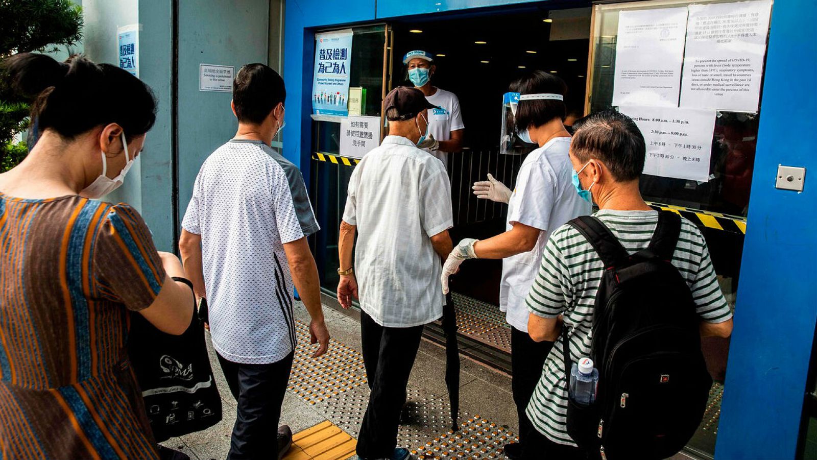 La gente espera en una cola en un centro de pruebas de coronavirus COVID-19 en Hong Kong.
