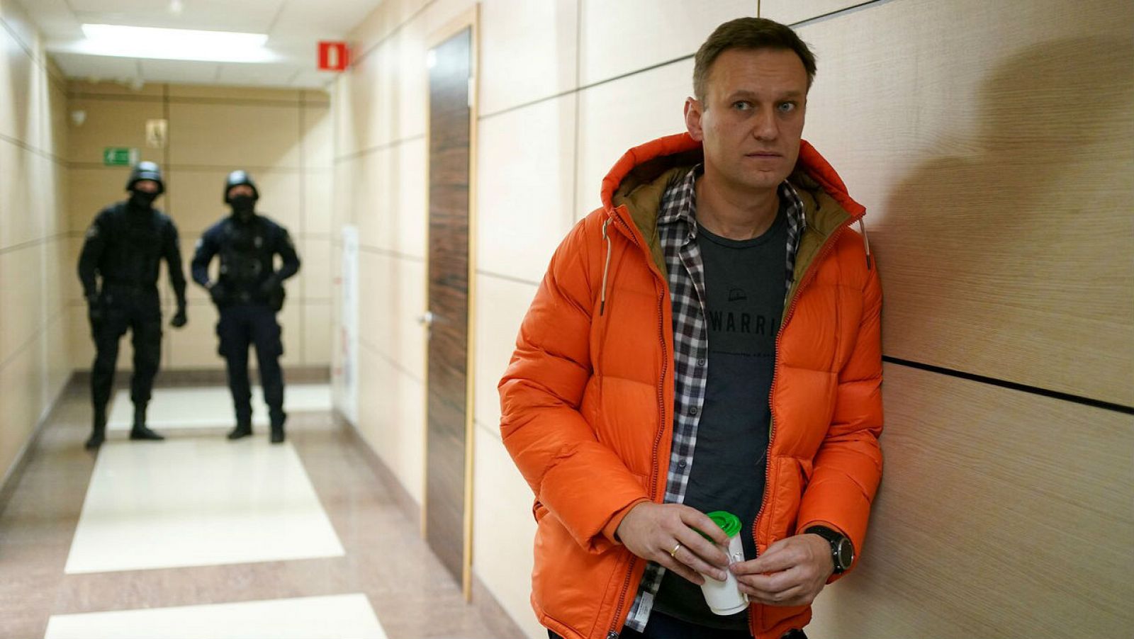 El líder de la oposición rusa, Alexei Navalny, de pie cerca de los agentes del orden en un pasillo de un centro de negocios, que alberga la oficina de su Fundación Anticorrupción (FBK), en Moscú.
