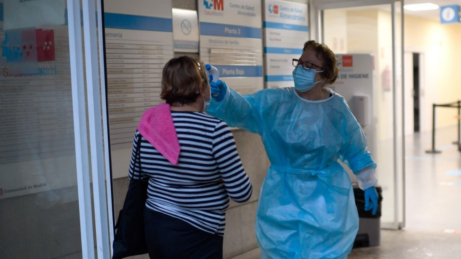 Una sanitaria toma la temperatura a una paciente en un centro de salud de Usera, Madrid. 