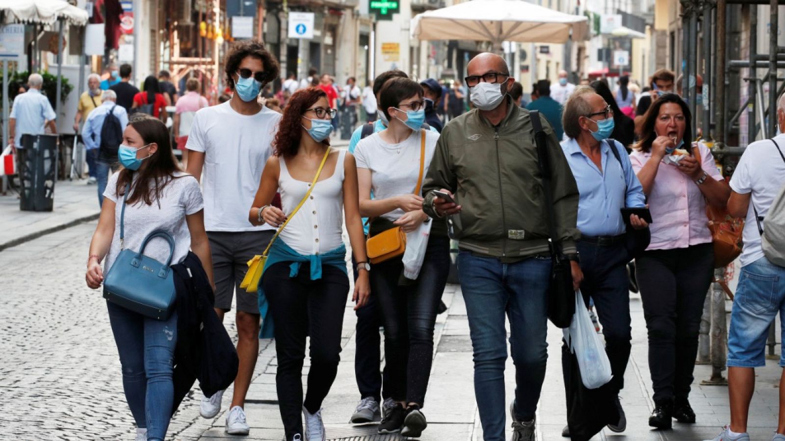 Un grupo de personas pasea por la calle con mascarilla