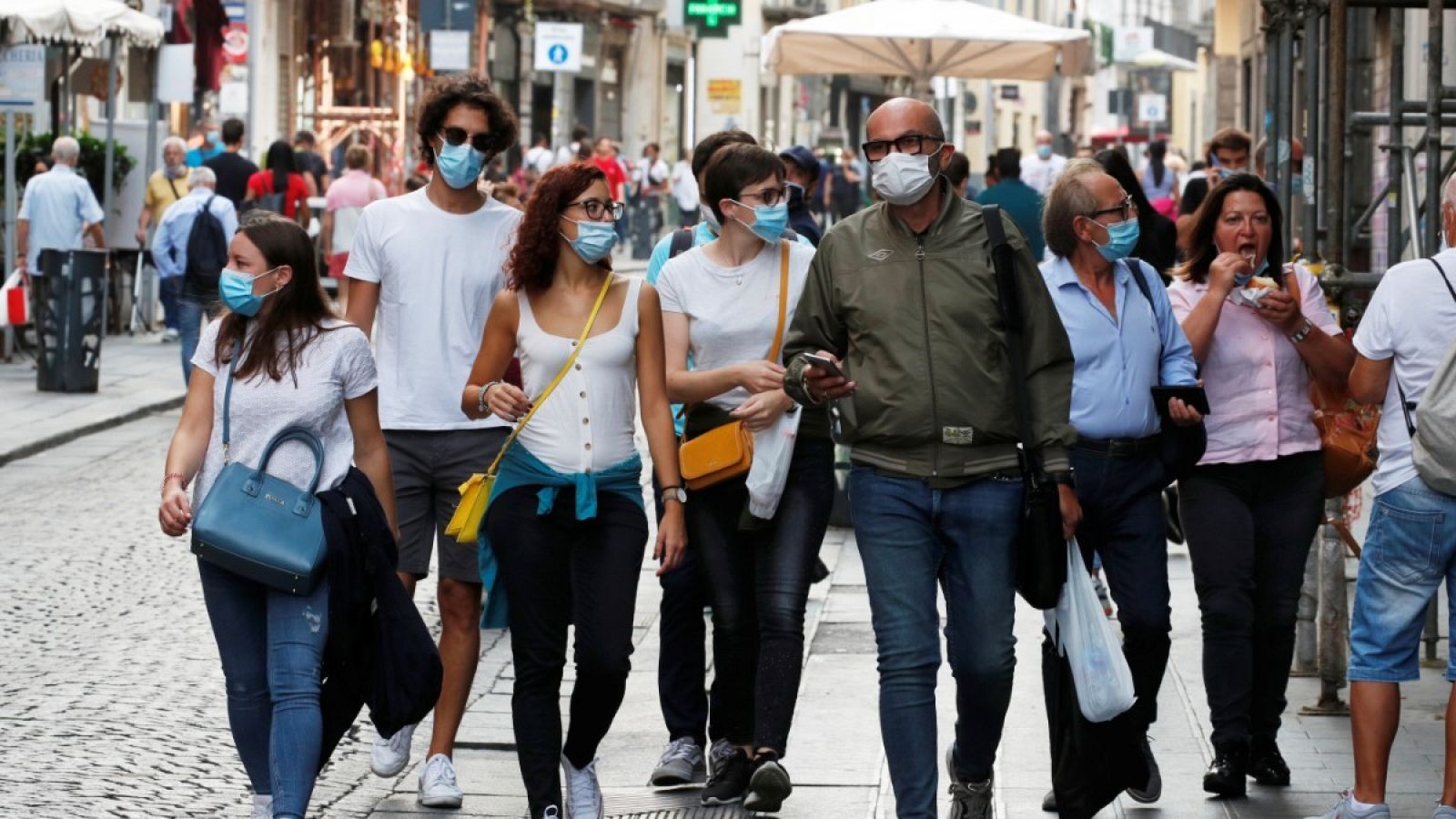 Un grupo de personas pasea por la calle con mascarilla 