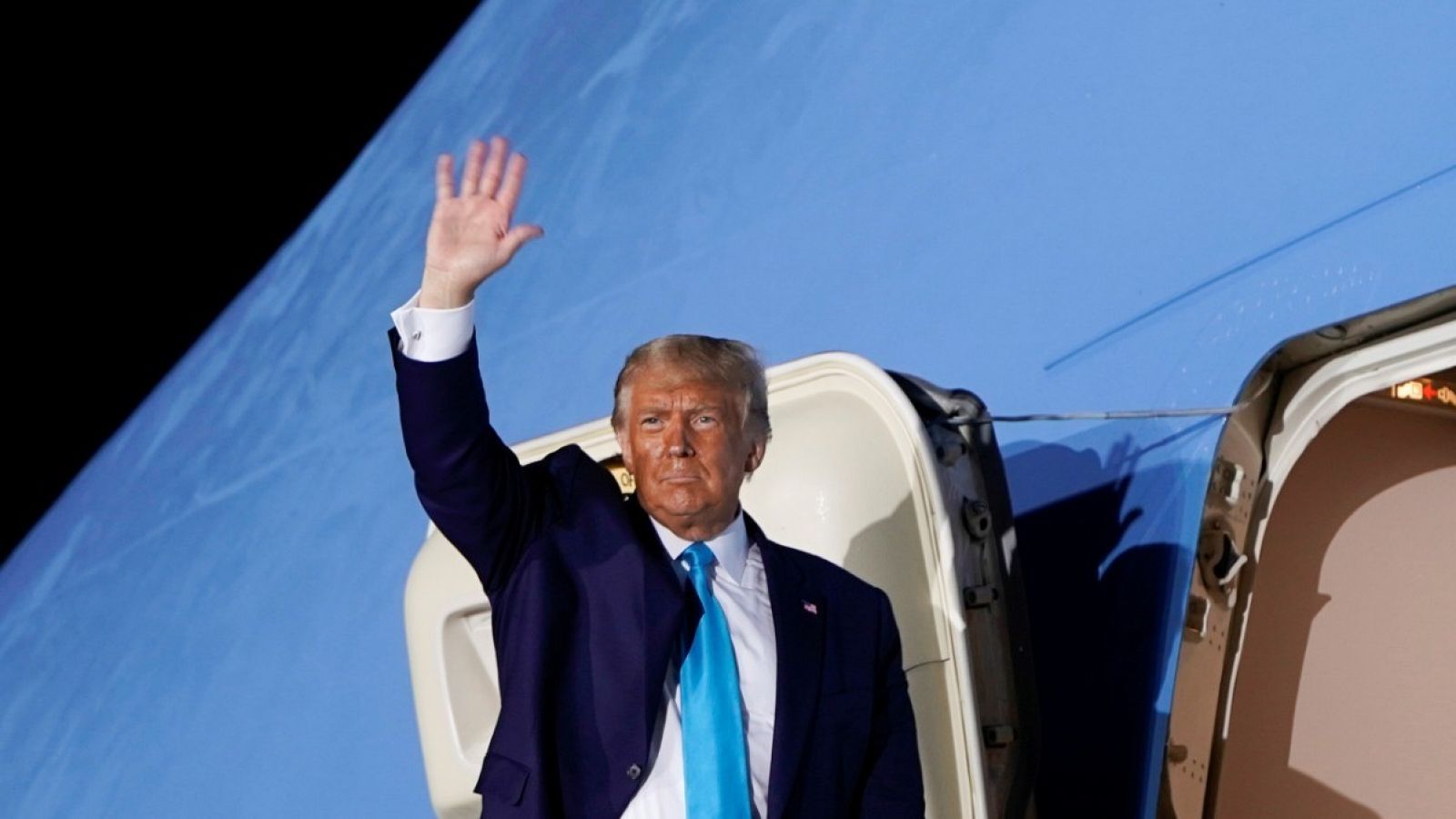 El presidente de Estados Unidos, Donald Trump, saluda desde la escalerilla del avión en el aeropuerto de Middletown, Pennsylvania.