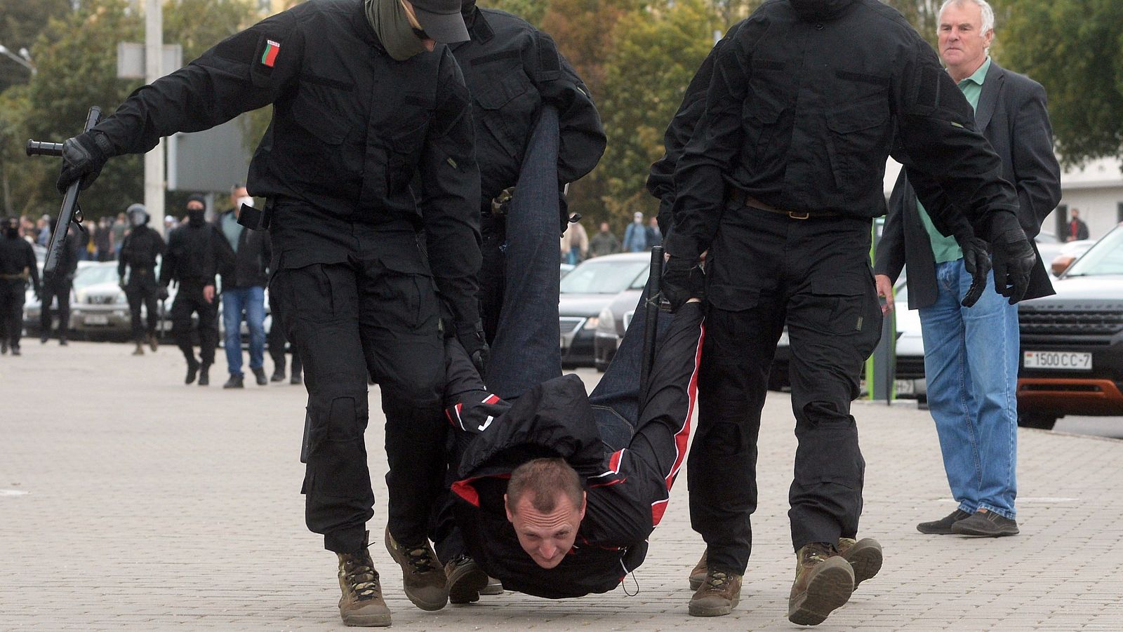 Cuatro policías bielorrusos llevan en volandas a una persona que se manifestaba contra Lukashenko.