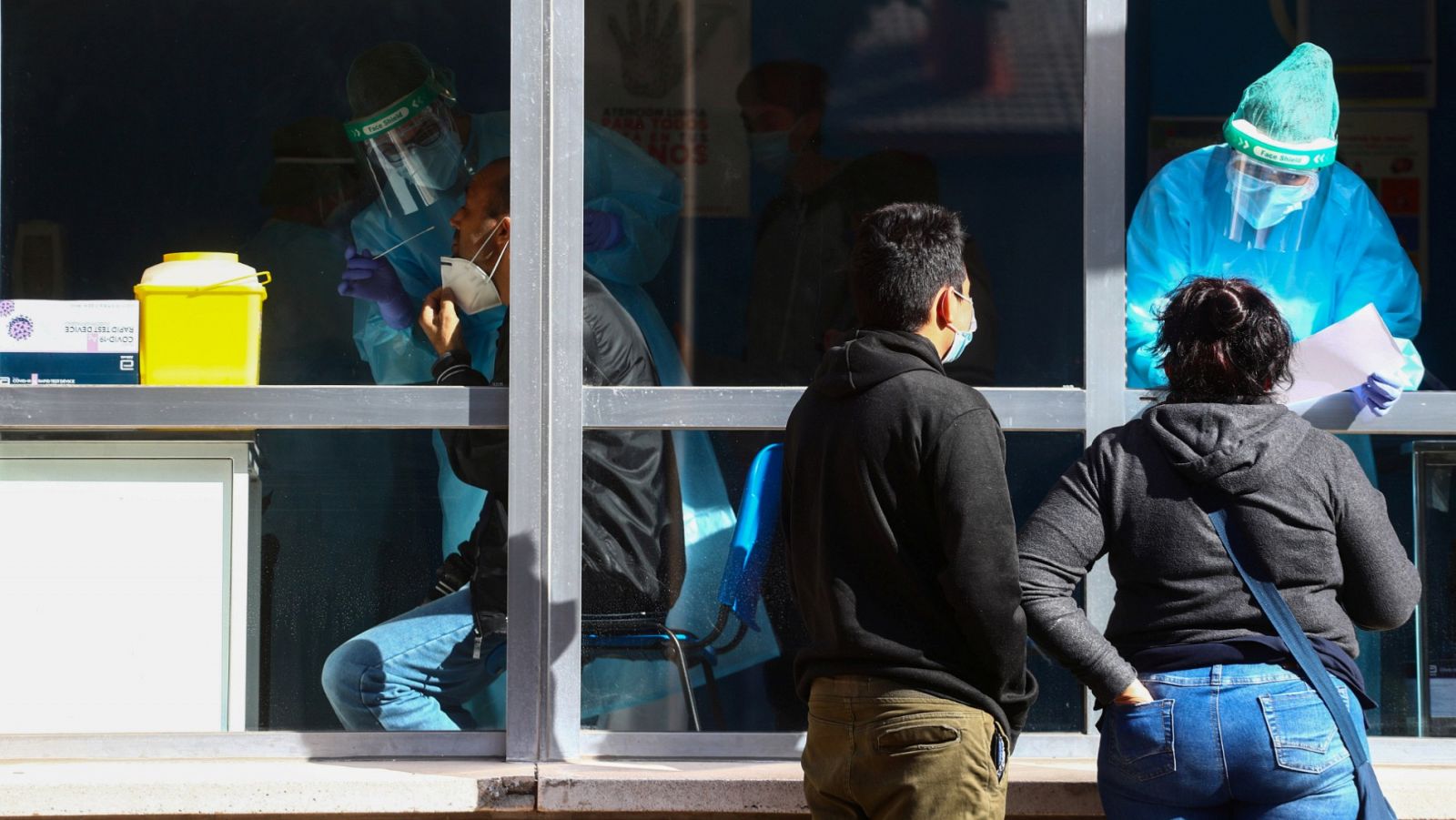 Un sanitario toma una muestra de hisopo a un paciente para la prueba de antígenos en Orcasitas (Madrid)