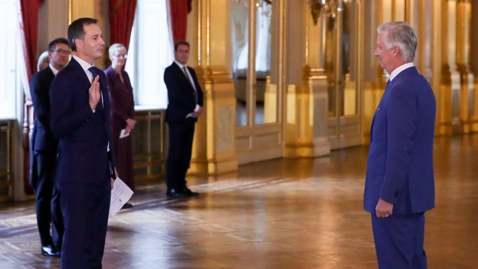 El nuevo primer ministro belga, Alexander De Croo, jurando su cargo ante el rey Felipe de Bélgica (d).