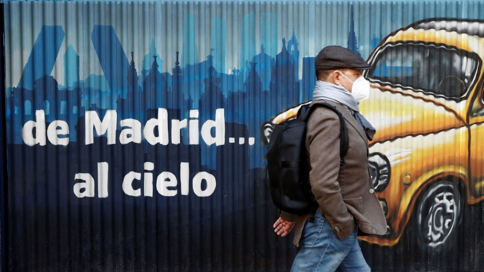 Una persona con mascarilla camina por una calle de Madrid