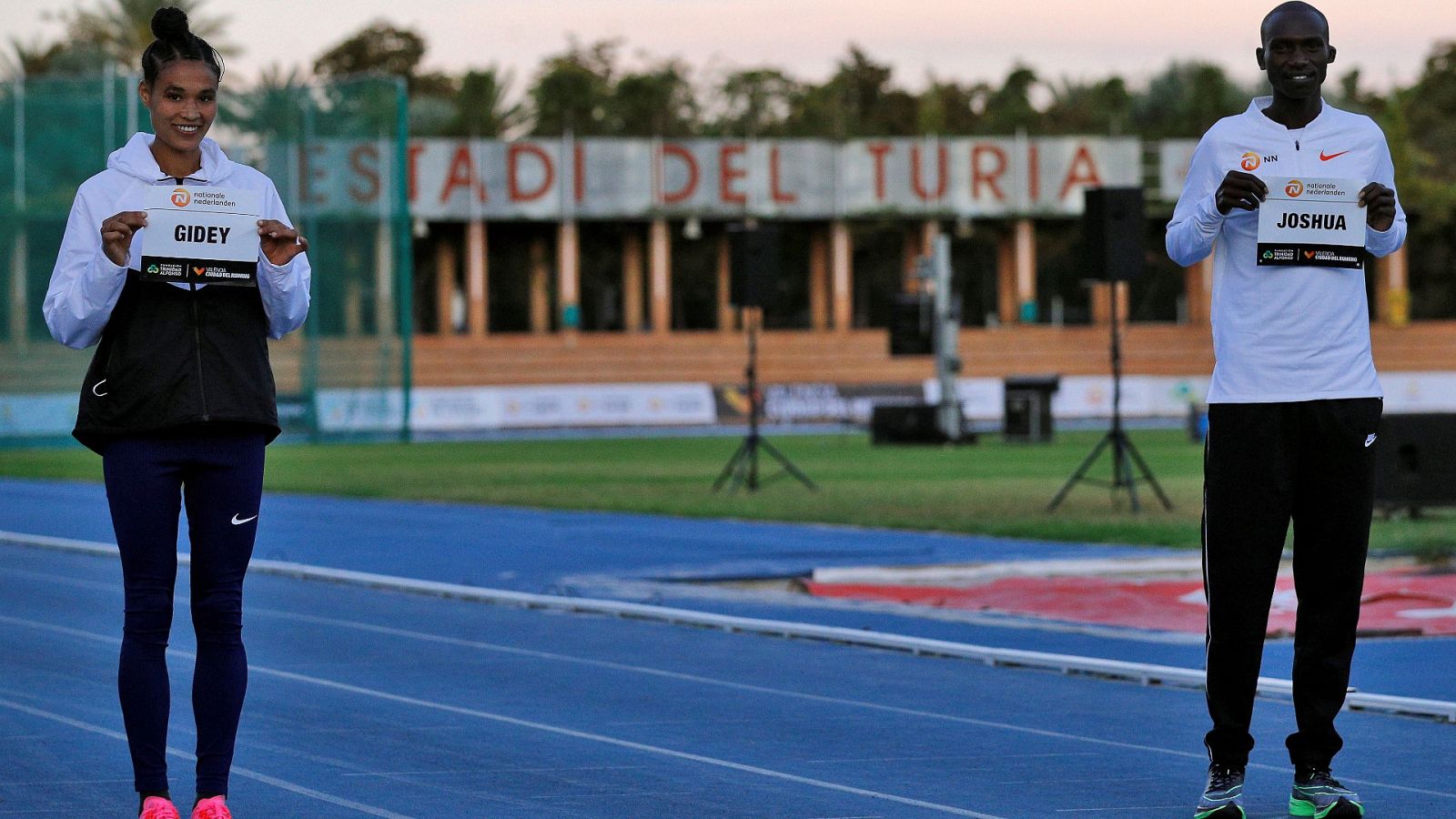 La atleta etíope Letensebet Gidey y el atleta ugandés Joshua Cheptegei, que este miércoles tratarán de batir los récord del mundo de los 5.000 y 10.000 metros lisos respectivamente, en el estadio Jardin del Túria de València, posan con sus dorsales.