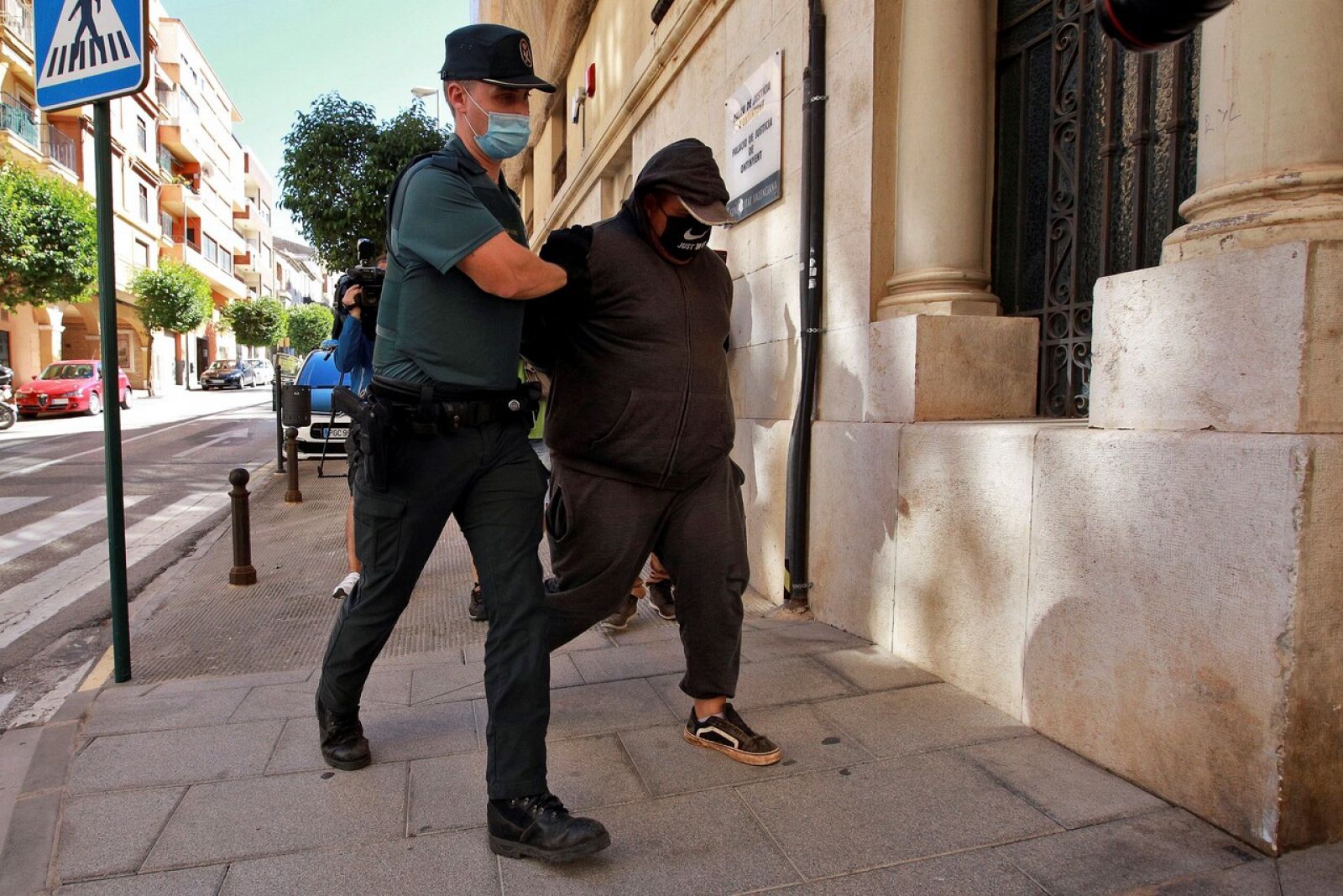 Un agente de la Guardia Civil traslada al Juzgado de Instrucción número 1 de Ontinyent, en Valencia, a uno de los detenidos por su supuesta participación en una violación grupal a una menor de 14 años en la localidad valenciana de l'Olleria que se pr