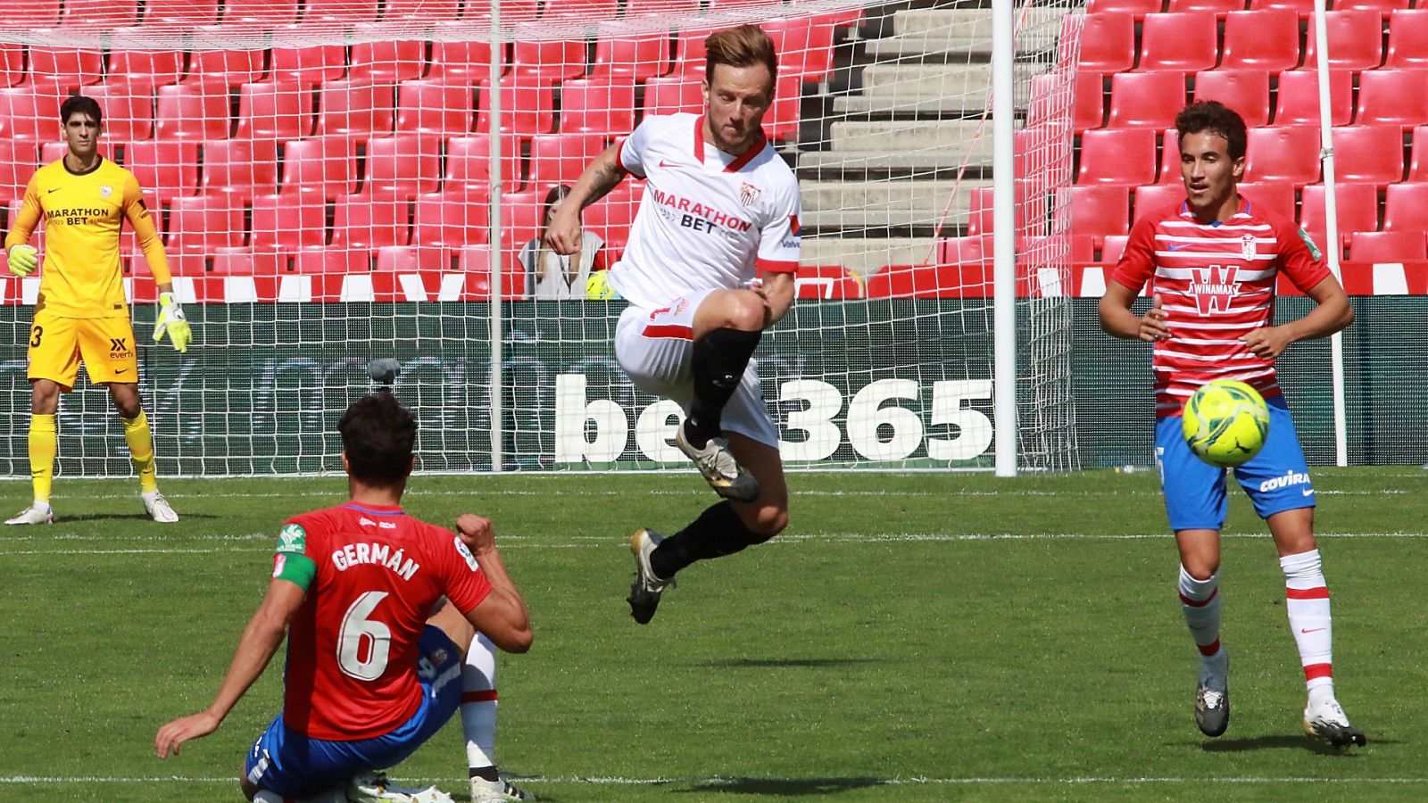 El jugador del Sevilla Rakitic despeja el disparo de Germán, del Granada