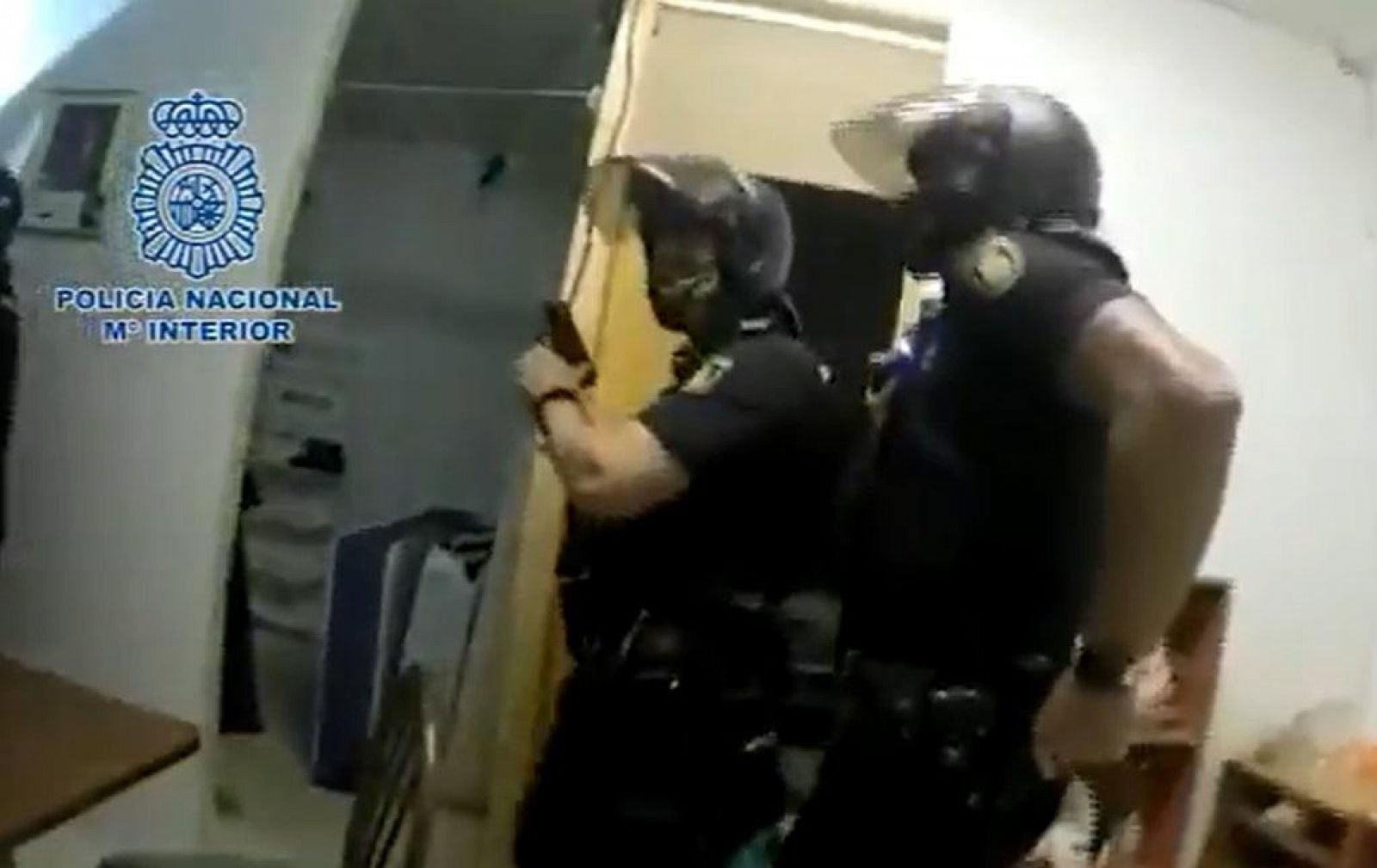 Policías en el registro de uno de los domicilios empleados por la organización para hacinar a inmigrantes en Córdoba.