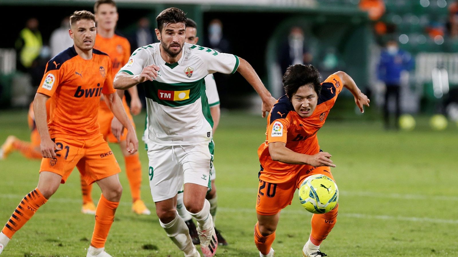 El defensa del Elche CF Antonio Barragán (c) persigue el balón con el coreano Kang-In Lee, del Valencia CF.