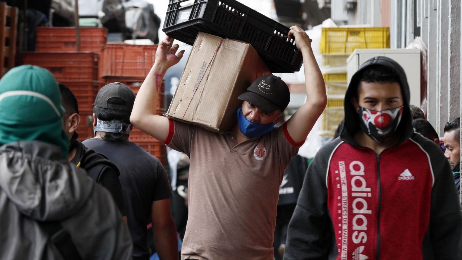 Varias personas usando mascarilla mientras trabajan en la plaza de mercado Corabastos en Bogotá, Colombia.