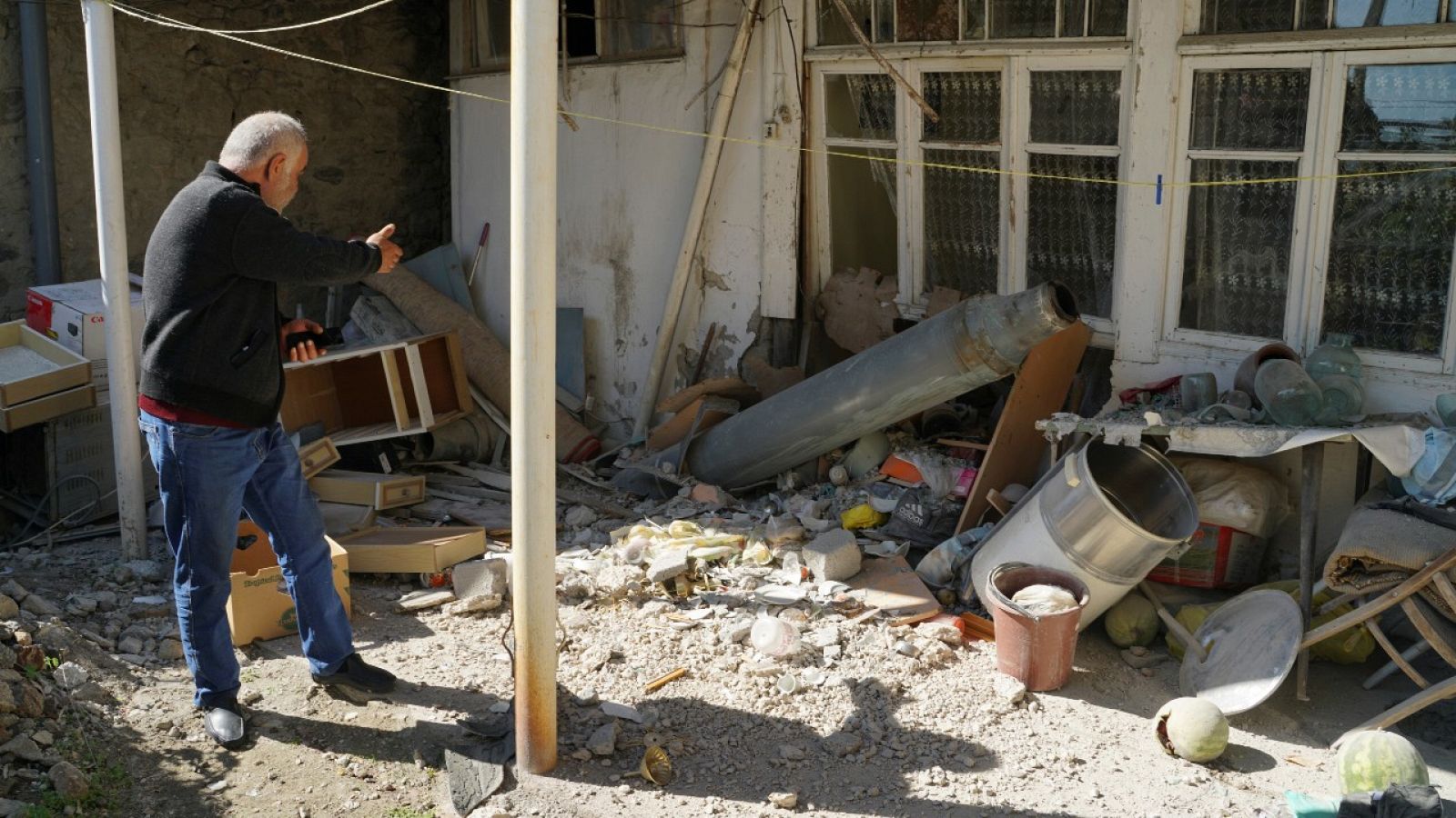 Un hombre muestra los daños producidos en una casa tras un ataque del Ejército de Azerbaiyán, en Stepanakert, en Nagorno Karabaj.