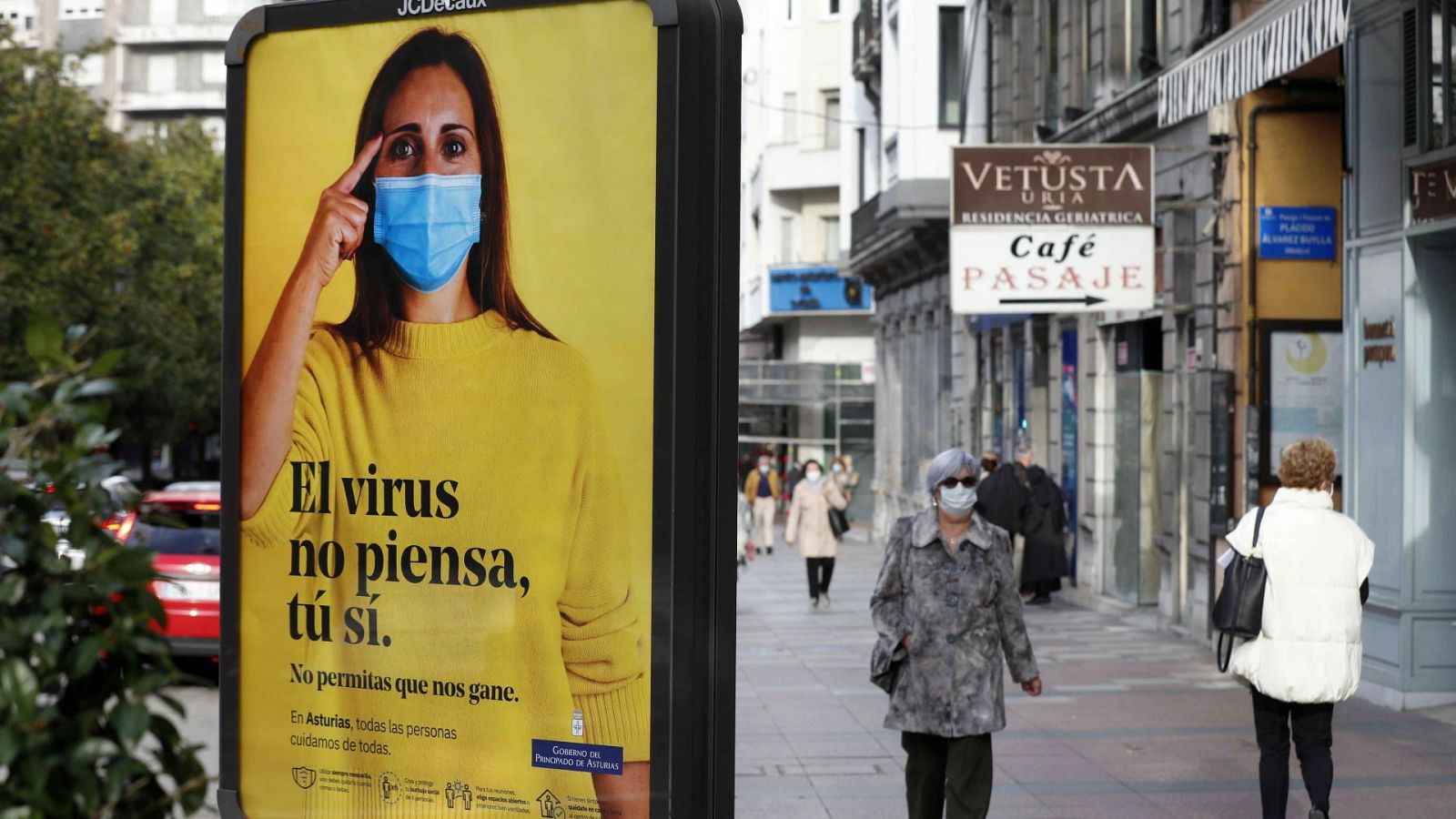 Vista de una calle del centro de Oviedo con un cartel sobre el coronavirus