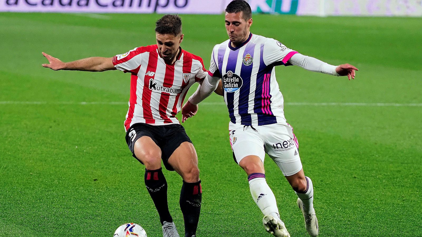 El centrocampista del Athletic Unai López juega un balón ante Guardiola, del Valladolid.