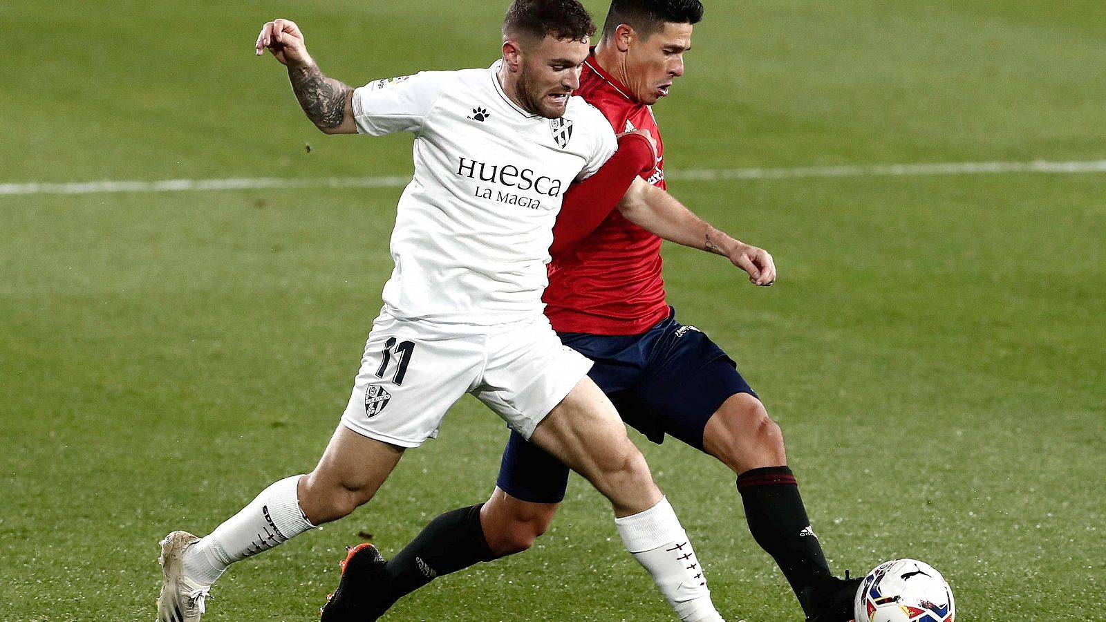 Facundo Roncaglia disputa el balón ante el jugador del Huesca, Javi Galán, durante el encuentro.