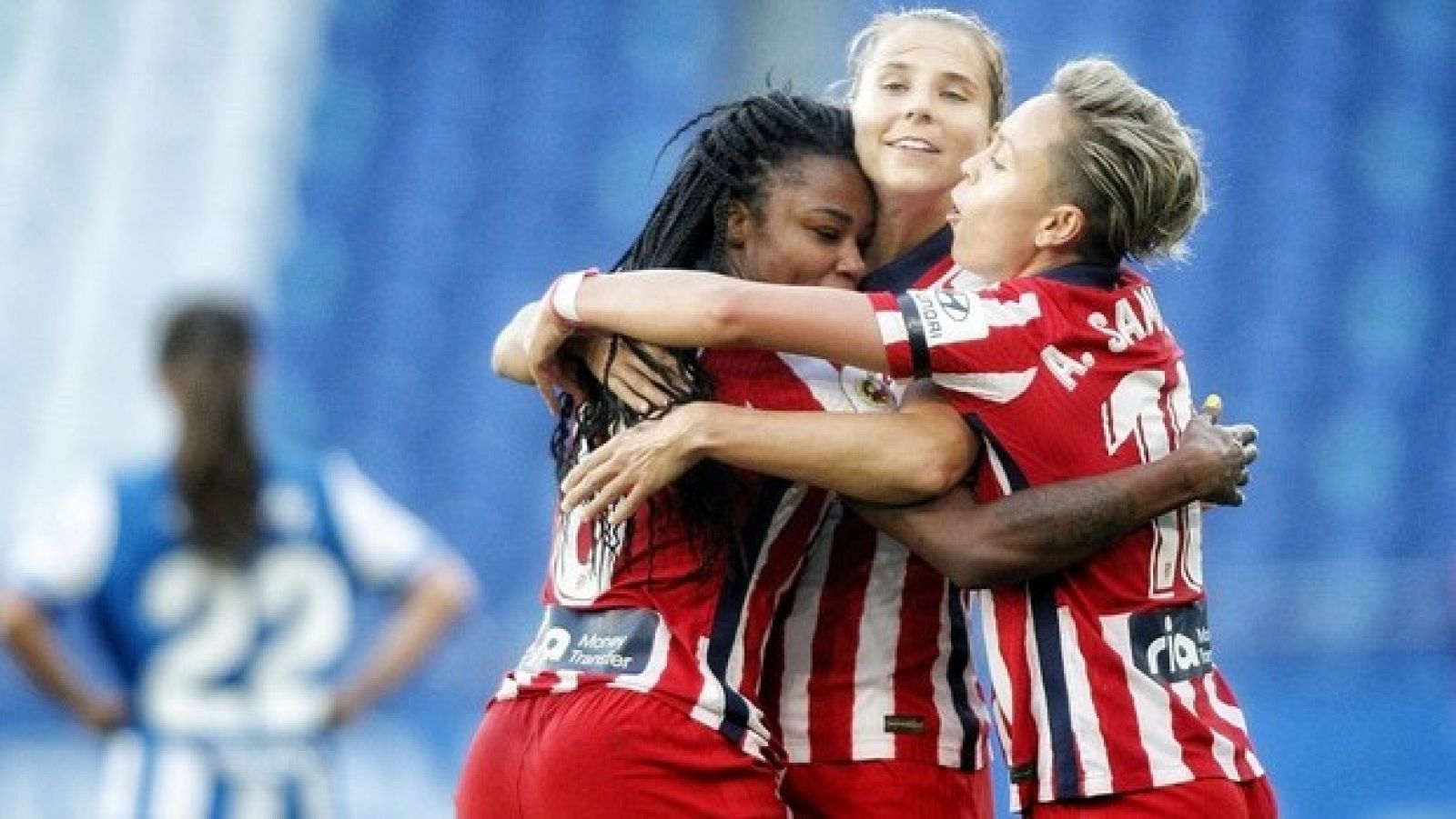 Tres jugadoras del Atlético de madrid femenino se abrazan tras anotar un gol