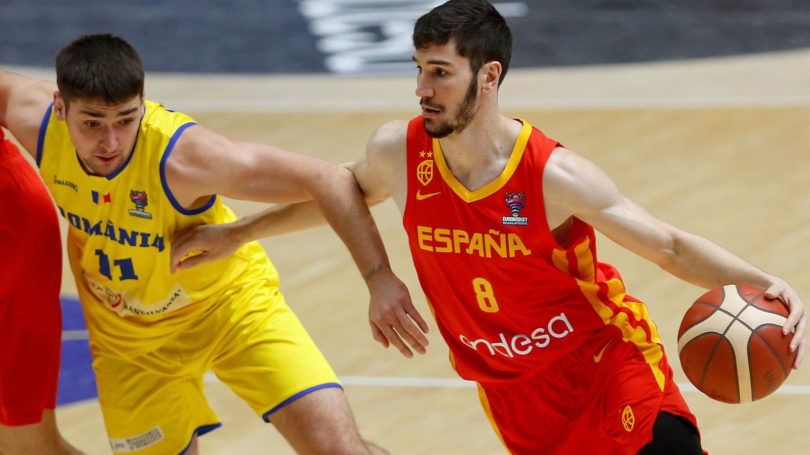 El escolta de la selección española de baloncesto Darío Brizuela (d) maneja el balón ante la oposición de Radu Virna (i), escolta de Rumanía